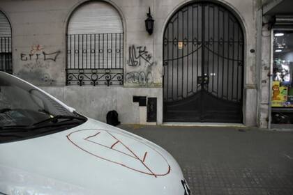 La imagen del auto estacionado frente a un garaje con el cartel de "prohibido estacionar"