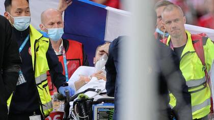 La imagen que tranquilizó al mundo: Christian Eriksen levanta la mano y asiente, luego de ser reanimado en plena cancha durante el partido entre Dinamarca y Finlandia por la Euro 2020.