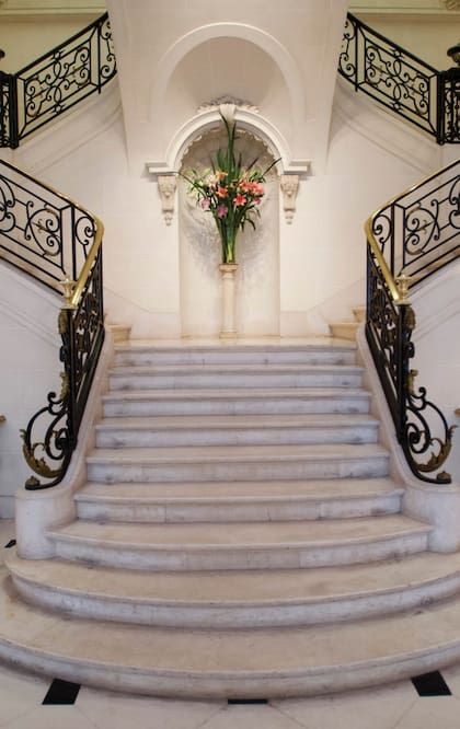 La imponente escalera de mármol blanco conecta la recepción con las habitaciones privadas de la planta alta.