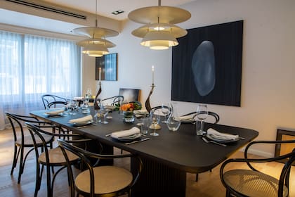 La imponente mesa negra (acompañada por un juego de sillas Thonet) ya está lista para recibir amigos a la noche.