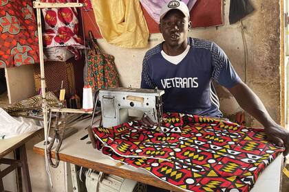 La integración laboral en la comunidad de origen salva vidas: Ndao es un maestro costurero de Mbour que hoy confecciona bolsos a mano.