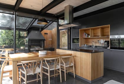 La isla y la mesa fueron diseñadas por el Estudio y se fabricaron con madera nativa reutilizada. Alacenas y bajomesadas de melamina brillante.