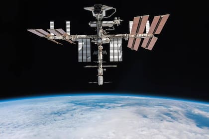 La ISS con el transbordador Endeavour en una de sus plataformas y al fondo el horizonte de la Tierra