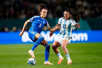 La italiana Barbara Bonansea, a la izquierda, y la argentina Florencia Bonsegundo luchan por el balón en el encuentro del Grupo G del Mundial femenino de fútbol entre Italia y Argentina en el Eden Park de Auckland, Nueva Zelanda, el lunes 24 de julio de 2023. (AP Foto/Abbie Parr)