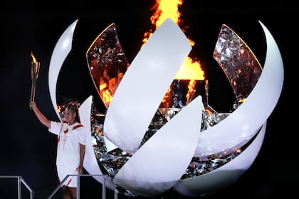 La japonesa Naomi Osaka enciende el pebetero durante la ceremonia de inauguración de los Juegos Olímpicos 2020, el viernes 23 de julio de 2021, en Tokio. (AP Foto/Ashley Landis)