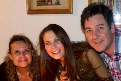 La joven con sus padres en una foto familiar