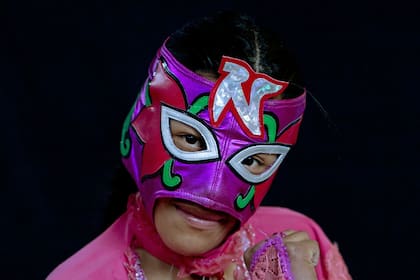 La joven luchadora Nelly Pankarita asume una pose con su máscara después de competir