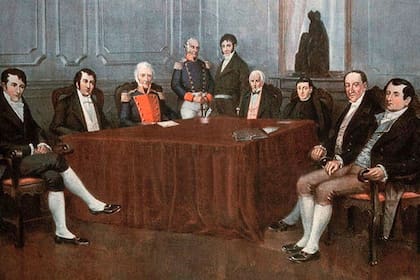 Cornelio Saavedra, al centro y con pechera roja y Miguel de Azuénaga, de pie a su lado, fueron los dos miembros de la Primera Junta de Gobierno que aprobaron el proyecto de la máquina submarina de Samuel William Taber