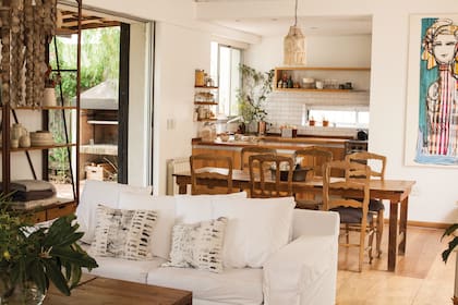 La lámpara del comedor la compraron en el puerto de frutos de Tigre. Y los almohadones del sillón los estampó la artista textil Germaine Bonifacio.