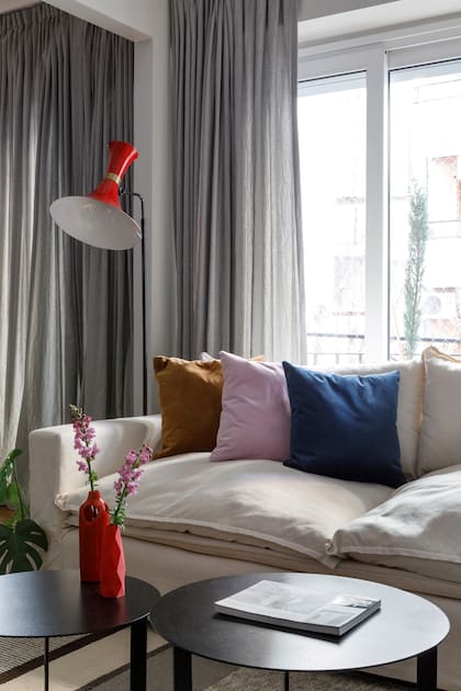 La lámpara es de Lamparista y los almohadones son de Delevie. Tanto en el living como en el comedor se colocaron cortinas de piso a techo confeccionadas por Gabriela Pérez Elizalde con textiles de Tienda Mayor. Floreros (Red Sur Design).