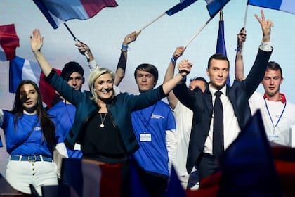 La líder del partido francés de ultraderecha Agrupación Nacional, Marine Le Pen, a la izquierda, y el candidato principal del partido para las próximas elecciones europeas, Jordan Bardella asisten a un acto político el domingo 2 de junio de 2024 en París. (AP Foto/Thomas Padilla)