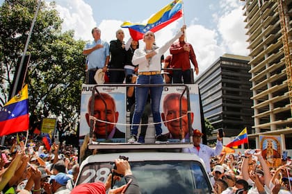 La líder opositora María Corina Machado ondea la bandera venezolana durante una manifestación para protestar contra los resultados oficiales que declararon a Nicolás Maduro como ganador en las elecciones presidenciales de julio en Caracas, Venezuela