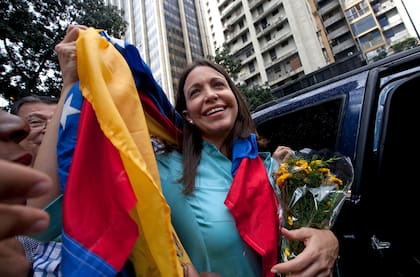 La líder opositora María Corina Machado sostiene la bandera venezolana frente a la Fiscalía General de la República, el miércoles 3 de diciembre de 2014, en Caracas, Venezuela