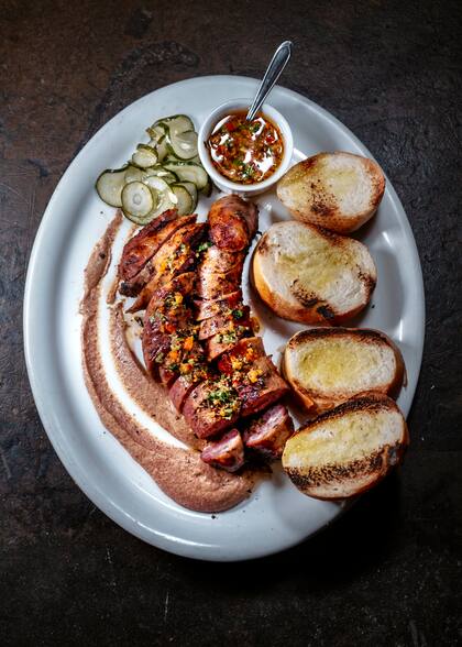 La linguiça (embutido de cerdo similar al chorizo) es elaborada de forma 100% artesanal, acompañada con chimichurri y rodajas de pan