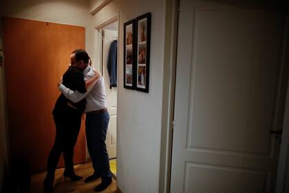 El médico Matías Norte abraza a su esposa Silvina en un pasillo de su departamento después de un largo día de trabajo con pacientes con Covid-19