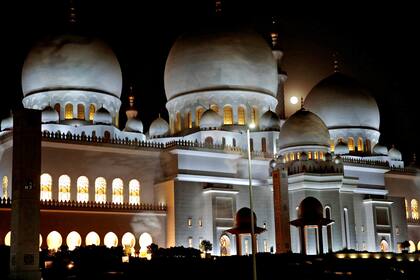 La luna se asoma detrás de un templo en la capital de los Emiratos Árabes