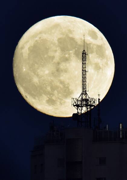 La luna se levanta sobre la atena de un edificio en Madrid