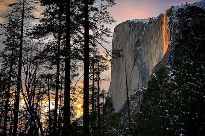 La luz ilumina al agua de una forma que hace que la cascada parezca hecha de fuego o lava