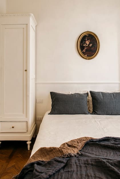 La madera de los pisos se vuelve protagonista en un ambiente blanco y despojado. Los almohadones, el pie de cama artesanal y un único cuadro son los únicos ornamentos.  