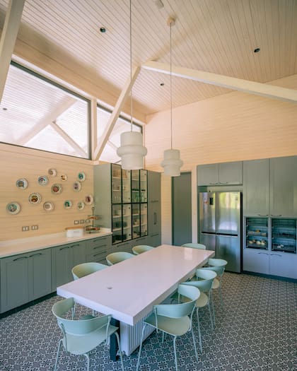 La madera laminada toma el cielo raso, la alzada de la cocina y un muro. Un detalle bajo la mesa: un radiador para pasar el invierno
