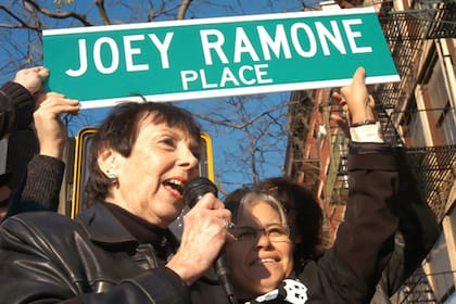 La madre de Joey Ramone, Charlotte Lesher, sostiene el carte de "Joey Ramone Place" durante la ceremonia en la que se rebautizó la esquina de la 2nd Street & Bowery, en honor a su hijo