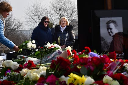 La madre del líder opositor Alexei Navalny, Lyudmila Navalnaya, y su suegra, Alla Abrosimova, visitan su tumba en el Cementerio Borisovskoye, en Moscú, Rusia, el 2 de marzo de 2024. (AP Foto)
