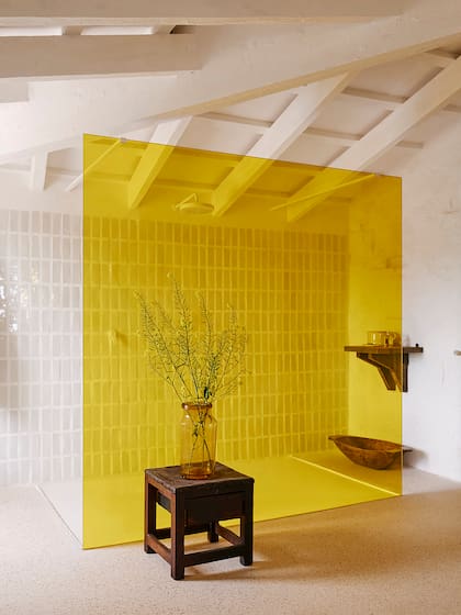 La mampara de vidrio amarillo es protagonista en el baño de la suite del arquitecto Luis Laplace.