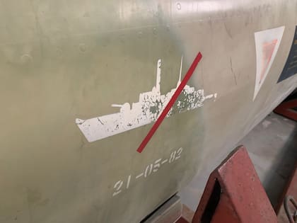 La marca de guerra o "Kill Mark" impuesta al Aermacchi finalizada la guerra. La silueta hace referencia a la fragata HMS Argonaut atacada por el piloto naval argentino. La silueta del barco está tachada por una sola marca, indica que fue averiada. Cuando tiene la cruz completa, quiere decir que fue hundida, (Cortesía de Owen Crippa).