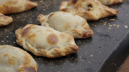 La masa lleva grasa vacuna y espolvorea los dobleces del hojaldre con almidón de maíz. Para el relleno mezcla carne de lomo, huevo duro, aceitunas picadas, orégano y aceite de oliva.