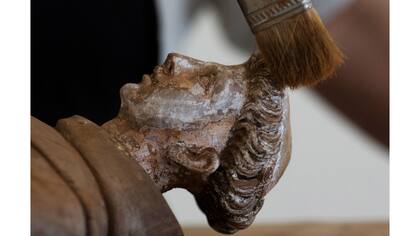 El restaurador Suely Gomes cepilla el barro apelmazado en una estatua de San Antonio del SXIX, en un centro de recuperación en Mariana, Brasil.