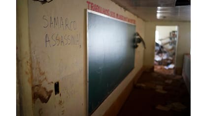 Un graffiti en portugués que dice; "Samarco asesino!" en la pared de una escuela destruida por el alud de barro