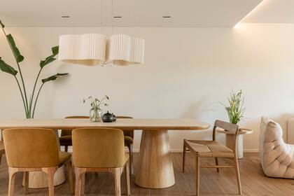 La mesa con pie de madera y tapa de dekton es un diseño de Paprika, las sillas y bancos de Navarro Habitat se acompañan con una lámpara protagonista (Mínimo Iluminación).