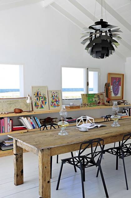 La mesa de comedor, encargada a un carpintero, con sillas apilables ‘Chair One’, de Konstantin Grcic, y la icónica lámpara ‘Artichoke’, del dañes Louis Poulsen.