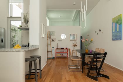 La mesa de La Feliz, sillas 'Cesca', silla alta de Stokke y lámpara colgante de Sabine Marselis para IKEA. Obra con celestes y verdes de Francisco Ratti.