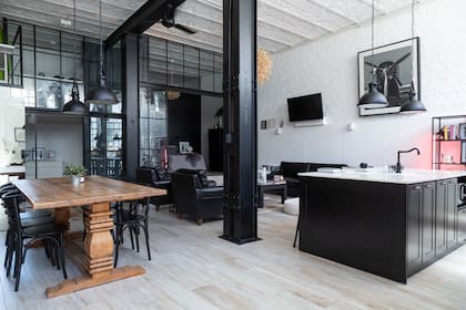 La mesa de madera corta con lo industrial del negro y el blanco de la caja arquitectónica. La luz rosa (@bronx.concept) otorga un toque original