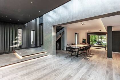 Los escalones avanzan sobre la galería para poder sentarse también allí. Con la buña y la luz, se buscó simular que flotan. La mesa del comedor (Fred), con tapa en Neolith. Sillas (Ananda Design)