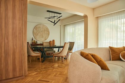 La mesa estilo Chippendale que traía la dueña de casa recibió un laqueado negro mate que realza su carácter atemporal. Sillas (Asuni Señor), cuadro (Paula Vinuesa Arte) y artefacto de luz (Vint Market). Sofá y almohadones (Divanlito).