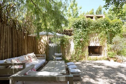 La mesa de este patio la hizo Luciano, el marido de Consuelo, con unos tablones de madera de anchico patinados luego en un tono gris pastel.