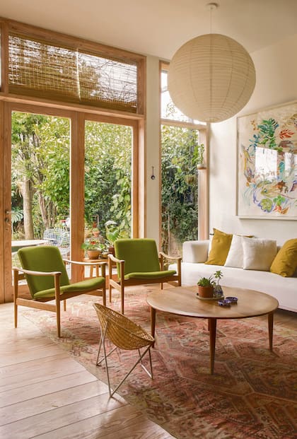 La mesa, las dos butacas escandinavas de petiribí tapizadas en lino verde teñido y la silla de ratán llevan su sello. Igual que los pisos y ventanas. 