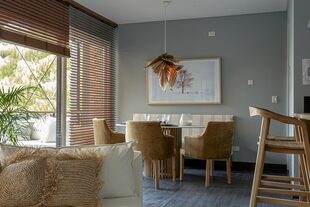 La mesa ovalada tiene una tapa fina de Dekton ‘Rem’ (Canteras del Mundo) trabajada por Marmolería Forte. Cortinas horizontales de madera de Hunter Douglas (Revestir S.A.).