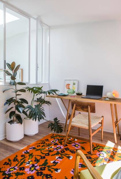 La mesa y la silla de líneas simples (La Base Studio) se acompañaron con una alfombra floreada (Elementos Argentinos).