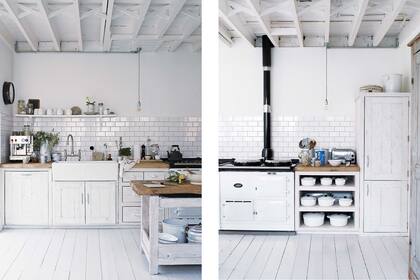 La mesada de pino recuperado con nudos a la vista es un cálido contrapunto campestre en la blanquísima cocina.