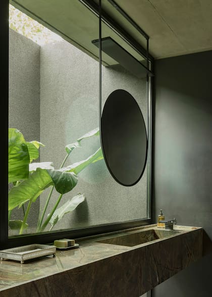 La mesada del toilette se resolvió con una bacha armada de Dekton. El espejo de hierro fue diseñado por el Estudio; cuenta con una bandeja superior para colgar plantas.