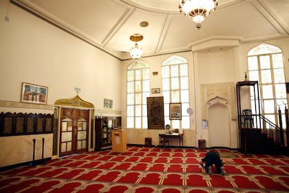 Un fiel realiza su oración frente a la quibla en el interior de la mezquita