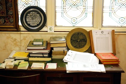 Una mesa y muchos libros contra el muro de orientación a La Meca, o quibla