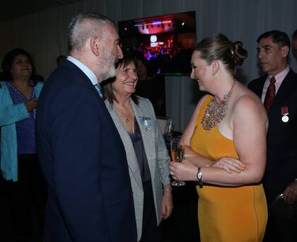 La ministra de Seguridad, Patricia Bullrich, y su esposo, Guillermo Yanco, saludan a la embajadora Kirsty Hayes