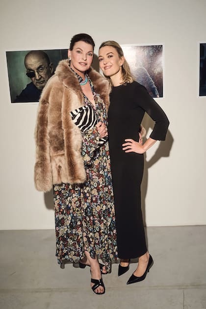 Model Linda Evangelista, wearing a floral dress and fur coat, poses with Marta