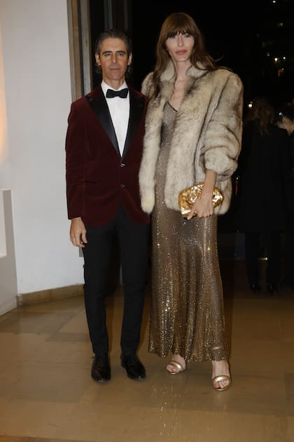 La modelo y galerista Dafne Cejas, con un diseño de Gicobbe, tapado Saint Laurent y clutch Bottega, junto a Andrés Cigorraga Pradère Castex