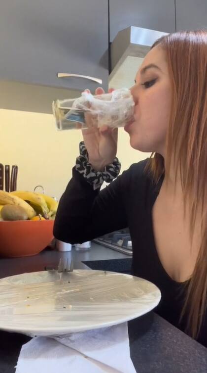 La mujer envuelve la vajilla con plástico para luego no lavarla