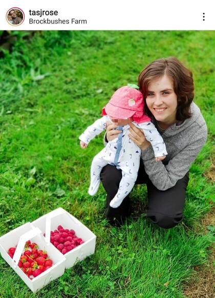 La mujer se muestra con su bebé en la naturaleza, juntando algunos frutos para alimentarse, siempre respetando su alimentación vegana